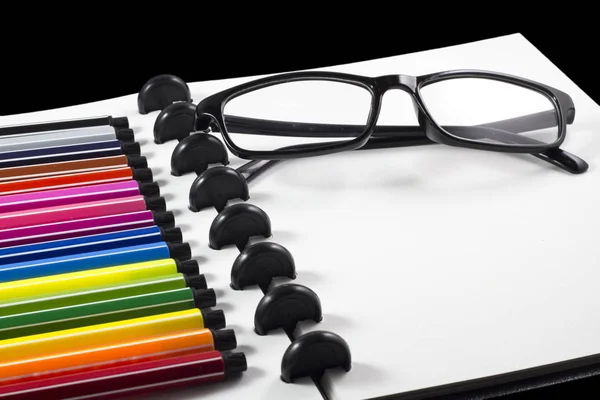 Renkli kalem ve eyeglesses için iş şablonu ile beyaz boş sketchbook
