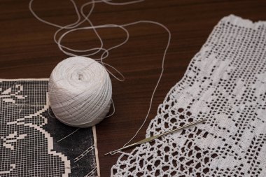 Tığ işi elbiseler ve masa üstleri, iplik topu manzarası gerekli ve tığ işi desenli.