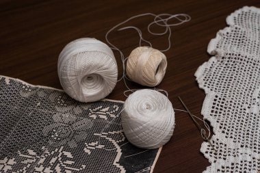 Tığ işi elbiseler ve masa üstleri, iplik topu manzarası gerekli ve tığ işi desenli.