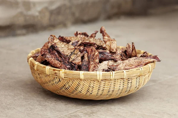 Ev yapımı kurutulmuş sığır ciğeri, taştan arka planda saman kabında cips. Köpek ve kedi kurutulmuş et ve ikramlar. Açık hava, kapalı, yumuşak seçici odak, kopyalama alanı. 