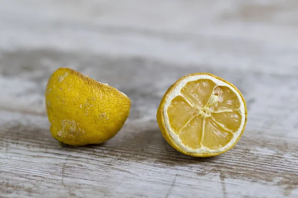 Expired citric fruits over a wooden background