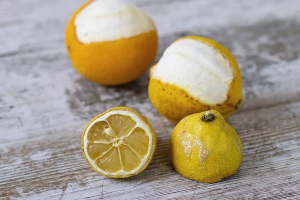 Expired citric fruits over a wooden background