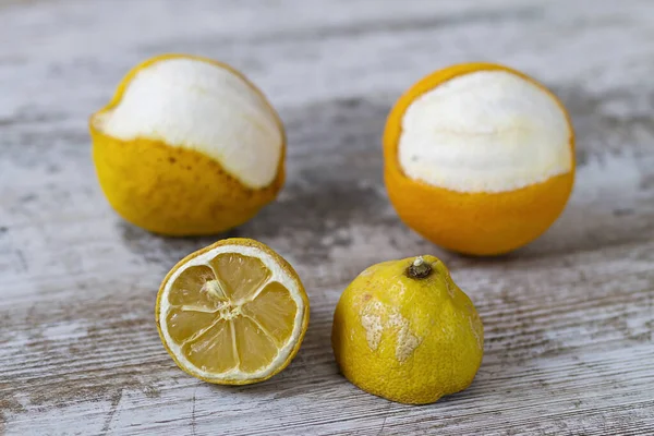 Expired citric fruits over a wooden background