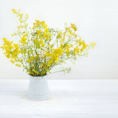 beyaz kır çiçekleri ile kova