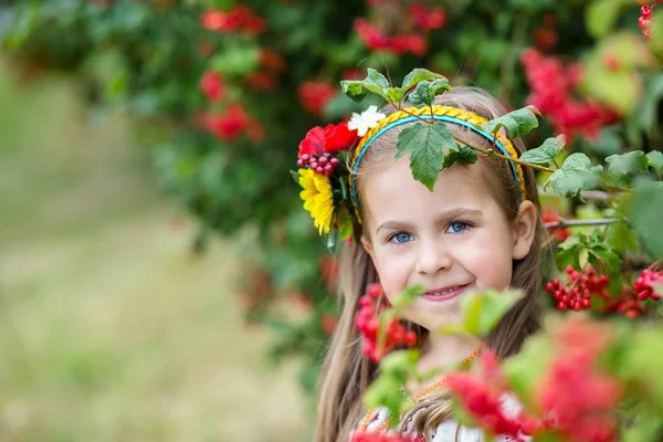 A little girl with blond hair in a Ukrainian folk costume stands near — Stock Photo, Image
