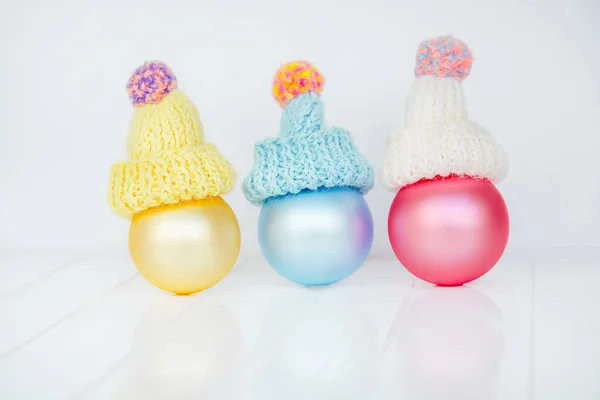 Bolas de decoração de Natal e guirlanda em um fundo branco. Três balões coloridos em um gorro na forma de bonecos de neve. Composição de Natal . — Fotografia de Stock