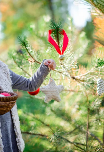 Mädchen hält Weihnachtsdekoration in einem Korb in der Hand. — Stockfoto