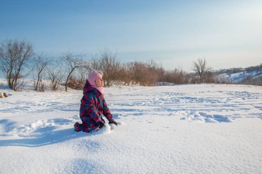 Neşeli kız güneşli bir kış gününde kar atıyor. Kar ile aktif oyunlar. Kış tatili.