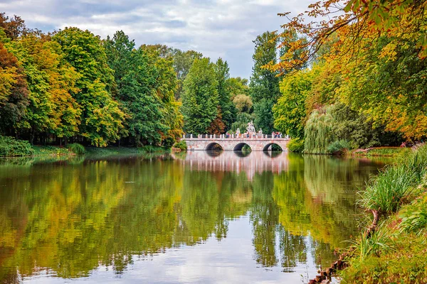 Puente en el parque en el lago. Palacio Real sobre el Agua en el Parque Lazienki, Varsovia. Vista al lago en otoño — Foto de Stock