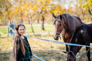 Ahırda çitin yanında durup atı okşayan mutlu kız..