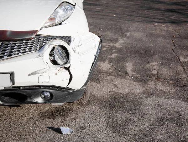 交通事故や事故。フロントウイングと右ヘッドライトが破損し、バンパーの損傷や傷があります。壊れた車の部品またはクローズアップ. — ストック写真