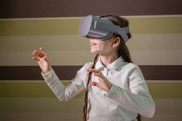 Dziewczyna z słuchawkami wirtualnej rzeczywistości. Dziewczyna bada świat wirtualnej rzeczywistości poprzez gry wideo i. — Zdjęcie stockowe
