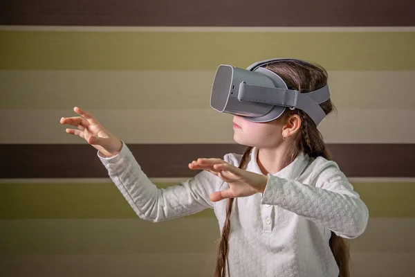 Meisje met een virtual reality headset. Het meisje verkent de wereld van de virtuele realiteit door middel van video en games. — Stockfoto