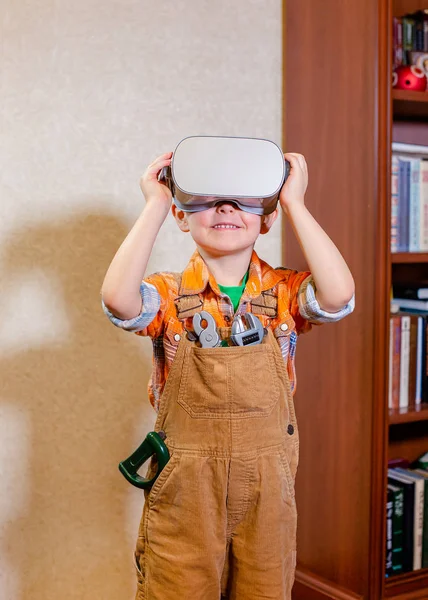 Een jongen ervaart virtuele realiteit, een rollenspel voor kinderen is een bouwer. — Stockfoto