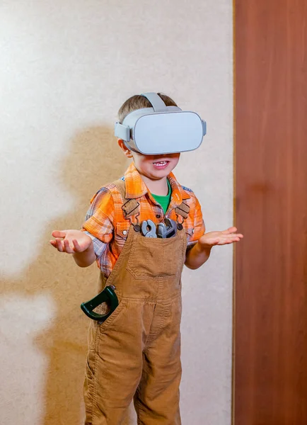 Een jongen ervaart virtuele realiteit, een rollenspel voor kinderen is een bouwer. — Stockfoto