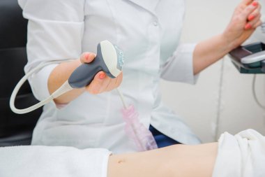 Ultrason tarayıcısıyla çalışan kadın doktor hastanın midesini muayene ediyor..