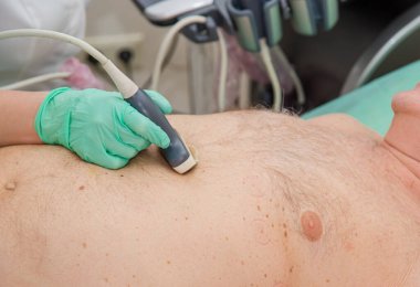 Kadın doktor ultrason tarayıcısıyla kalp bölgesini inceliyor..