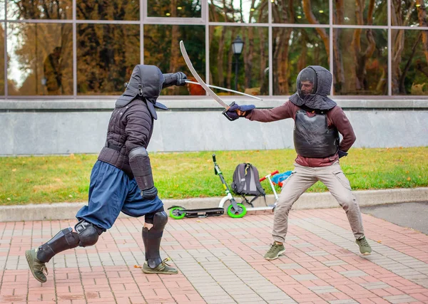 Dva ozbrojení muži vedou souboj s mečem, středověký souboj, na zábavném středověkém turnaji. Sportovní soutěže. — Stock fotografie