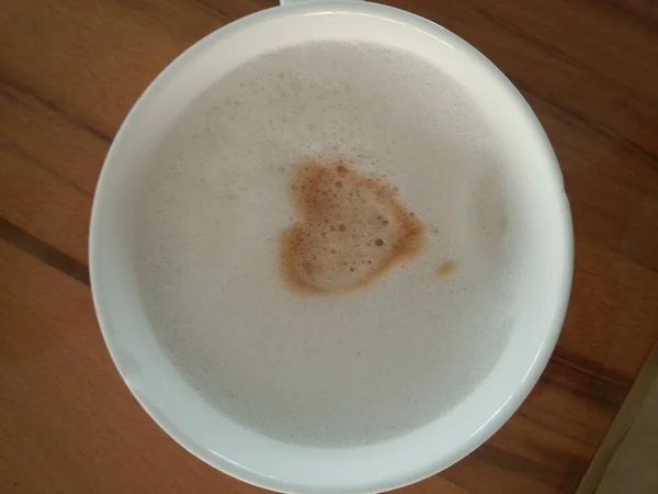 Капучино с молочной пеной и кофейным сердцем — стоковое фото
