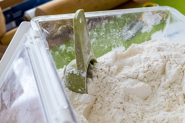 Harina con cuchara dosificadora en una caja de plástico —  Fotos de Stock