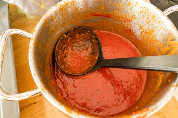 Tomato sauce is heated in a pot — Stock Photo, Image