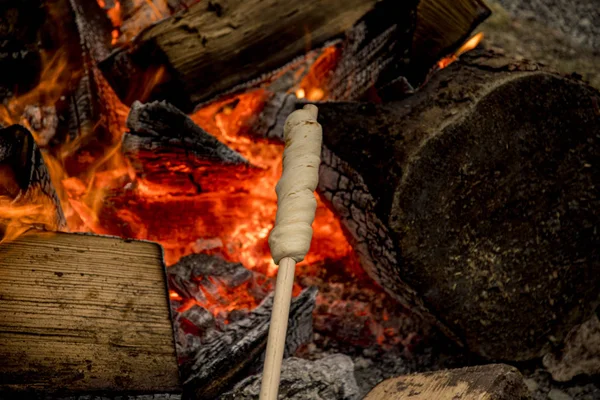 Stockbrot in der Glut eines Lagerfeuers zubereiten — Stockfoto