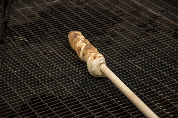 Preparando pão de pau nas brasas de uma fogueira — Fotografia de Stock