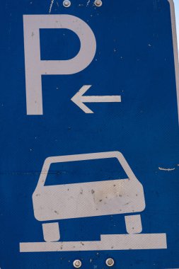 P harfli mavi bir park levhası ve bir araba.