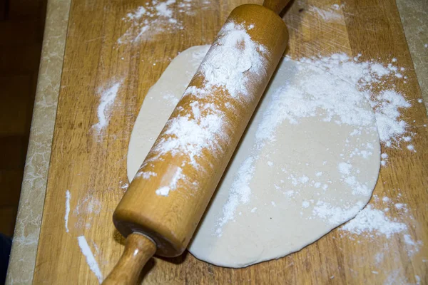 La masa de pizza redonda se despliega con harina y tablero de madera — Foto de Stock