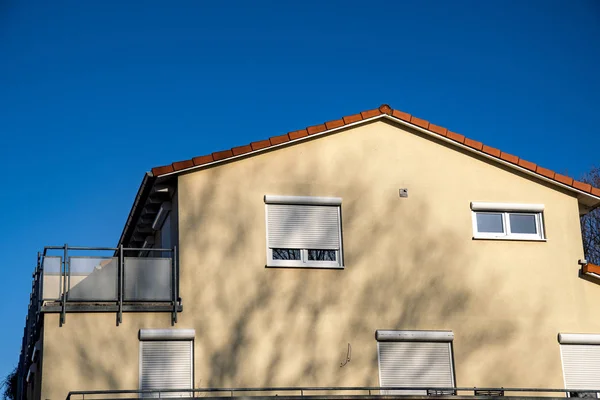Dům se střešním balkónem na modré obloze s okny — Stock fotografie