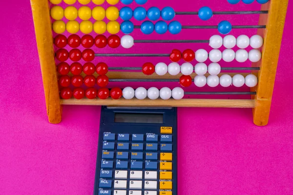 Calculator with abacus and bank notes on pink — Stock Photo, Image