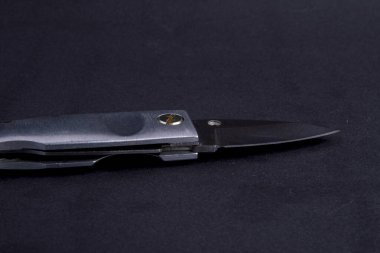 Keskin bıçaklı, siyah arka planda küçük bir çakı.