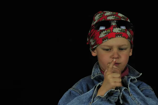 Little boy with gangs headscarf sunglasses and pistol finger