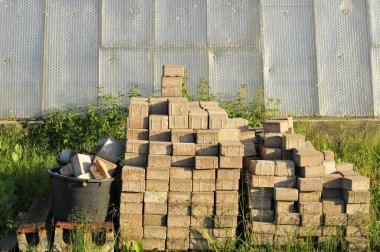 Yol kenarına kaldırım taşları yığılmış.