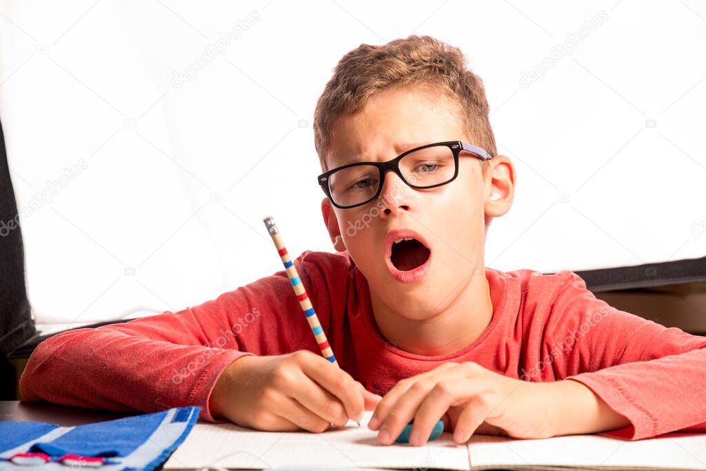 Boy yawns during lessons at home during the Corona Lockdown