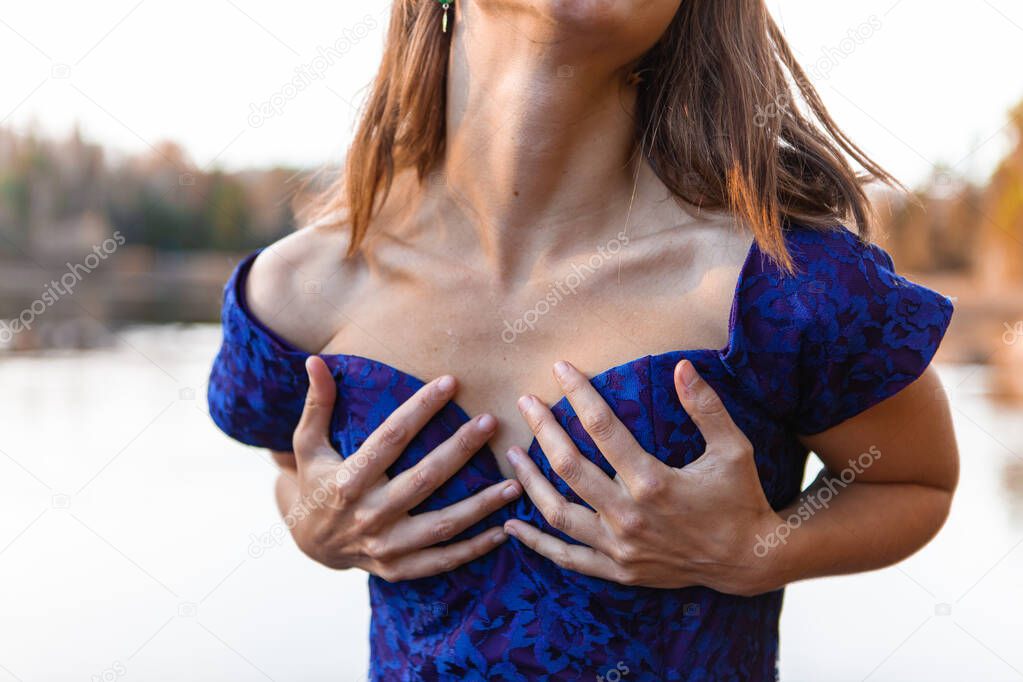 Young woman holding her breasts