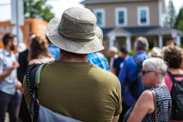 Mannen med hatt lyssnar på ett offentligt tal. — Stockfoto