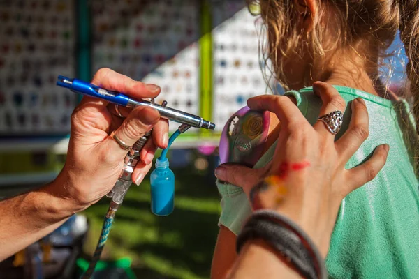 Young girl getting an airbrush stencil temporary tattoo — Stock Photo, Image