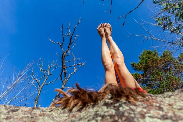 Giovane donna in abito rosso sta puntando le gambe mentre si sdraia sulla schiena — Foto Stock