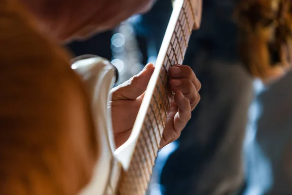 Guitarrista está tocando un solo en su guitarra eléctrica blanca en un pub — Foto de Stock