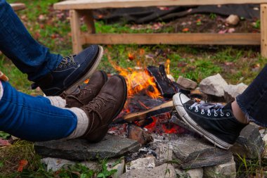 Dışarıdaki kamp ateşinin etrafında ayaklar 