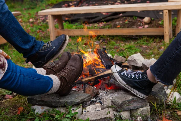 Feet around a camp fire outdoors