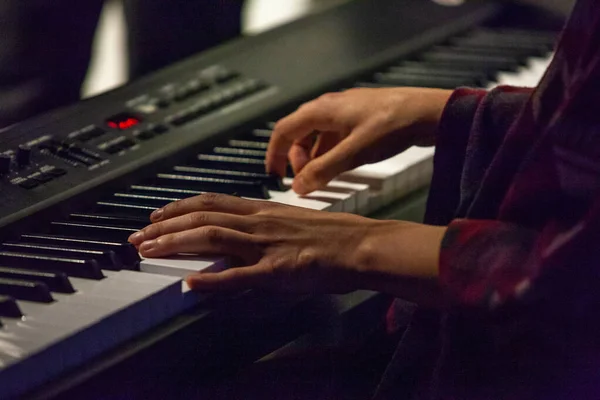 Mujer joven toca el piano digital en un pub — Foto de Stock