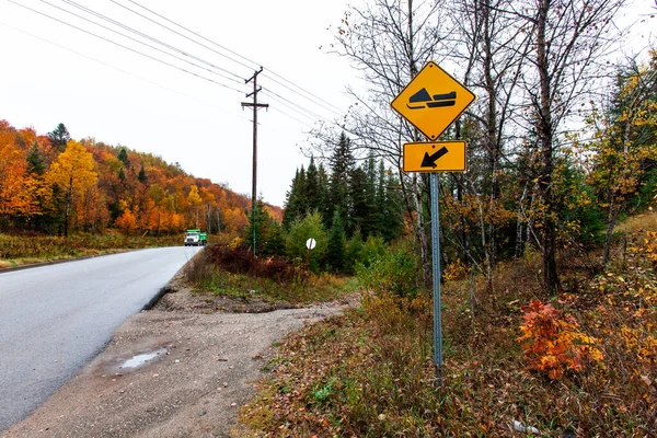 Snowmobile trať k levé žluté silniční značky, jak je vidět z boku silnice — Stock fotografie