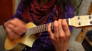 Oturma odasında gitar çalan adam..