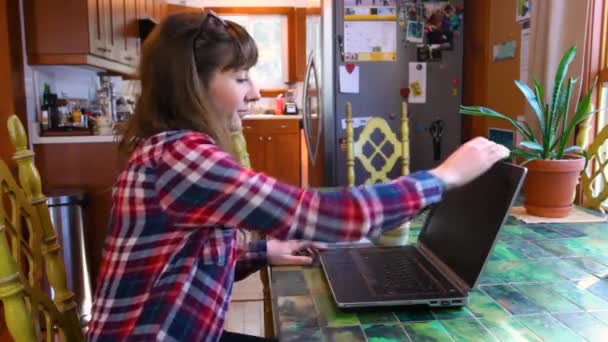Женщина за столом, работающая с ноутбуком — стоковое видео