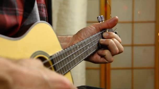 Hombre tocando música en un ukelele . — Vídeos de Stock