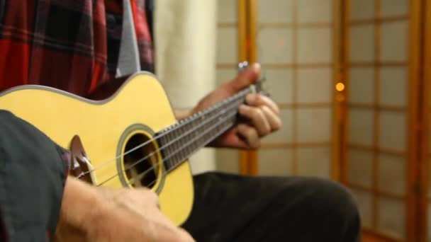 Человек играет музыку на укулеле . — стоковое видео