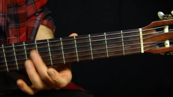 Man trimmar sin gitarr med harmonier. — Stockvideo