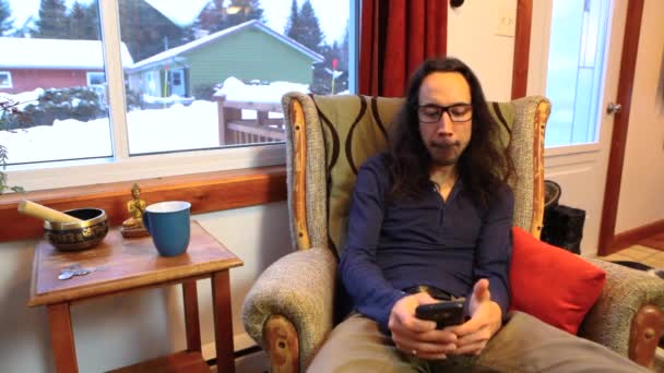 Чоловік використовує мобільний телефон у вітальні — стокове відео